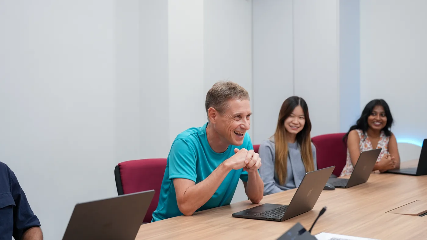 Three members of the n1 team talking around a table
